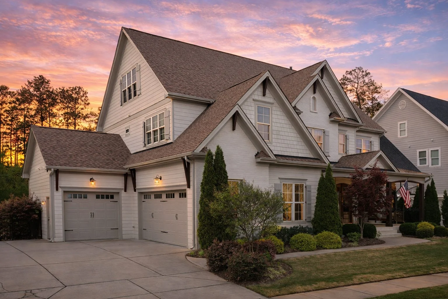 Front elevation of Traditional Colonial style home with horizontal lap siding, stone veneer accents, gabled rooflines, and symmetrical windows