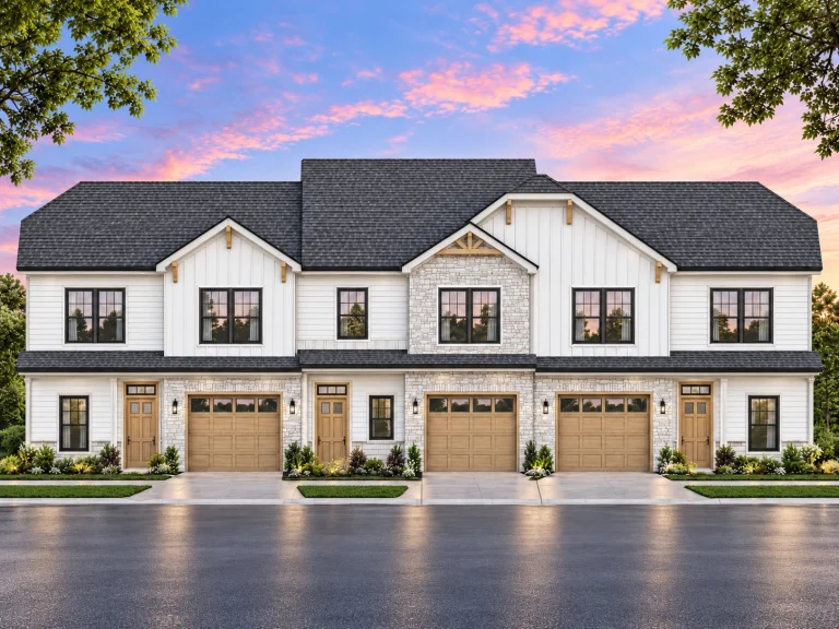 Front view of Modern Farmhouse style duplex featuring board and batten siding, brick and stone accents, and symmetrical garage entrances