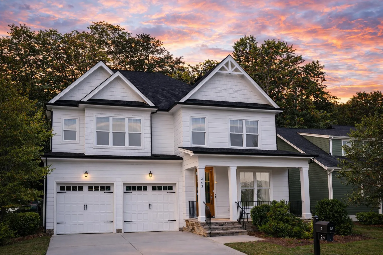 Front elevation of a Traditional two-story home featuring stone and horizontal siding exterior, black-framed windows, and double front-entry garage