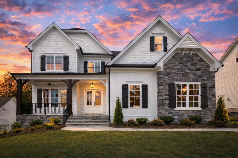 Front elevation of a New American style house featuring stone veneer, horizontal siding, gabled rooflines, and a covered front porch