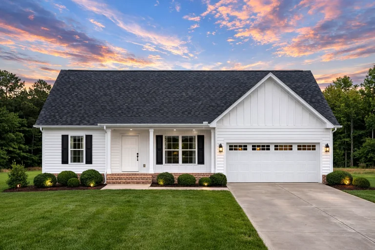 Front view of a Traditional Ranch style house featuring horizontal lap siding, board and batten gable accents, and a welcoming covered porch with attached two-car garage