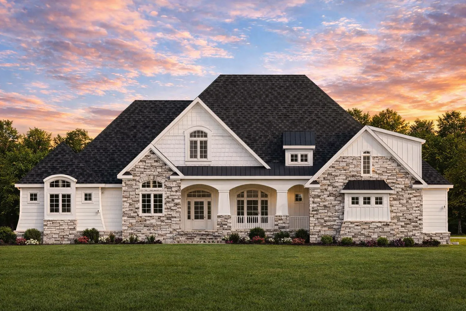 Front exterior of French Country style home with stone veneer, steep hip roof, arched entry, and board and batten gables