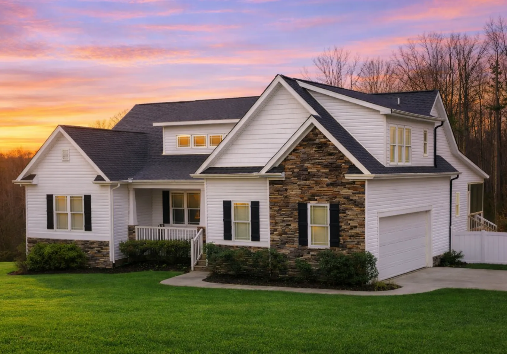 Front view of a Modern Farmhouse style home featuring board and batten siding, stone base accents, dark shutters, and a welcoming covered porch entry