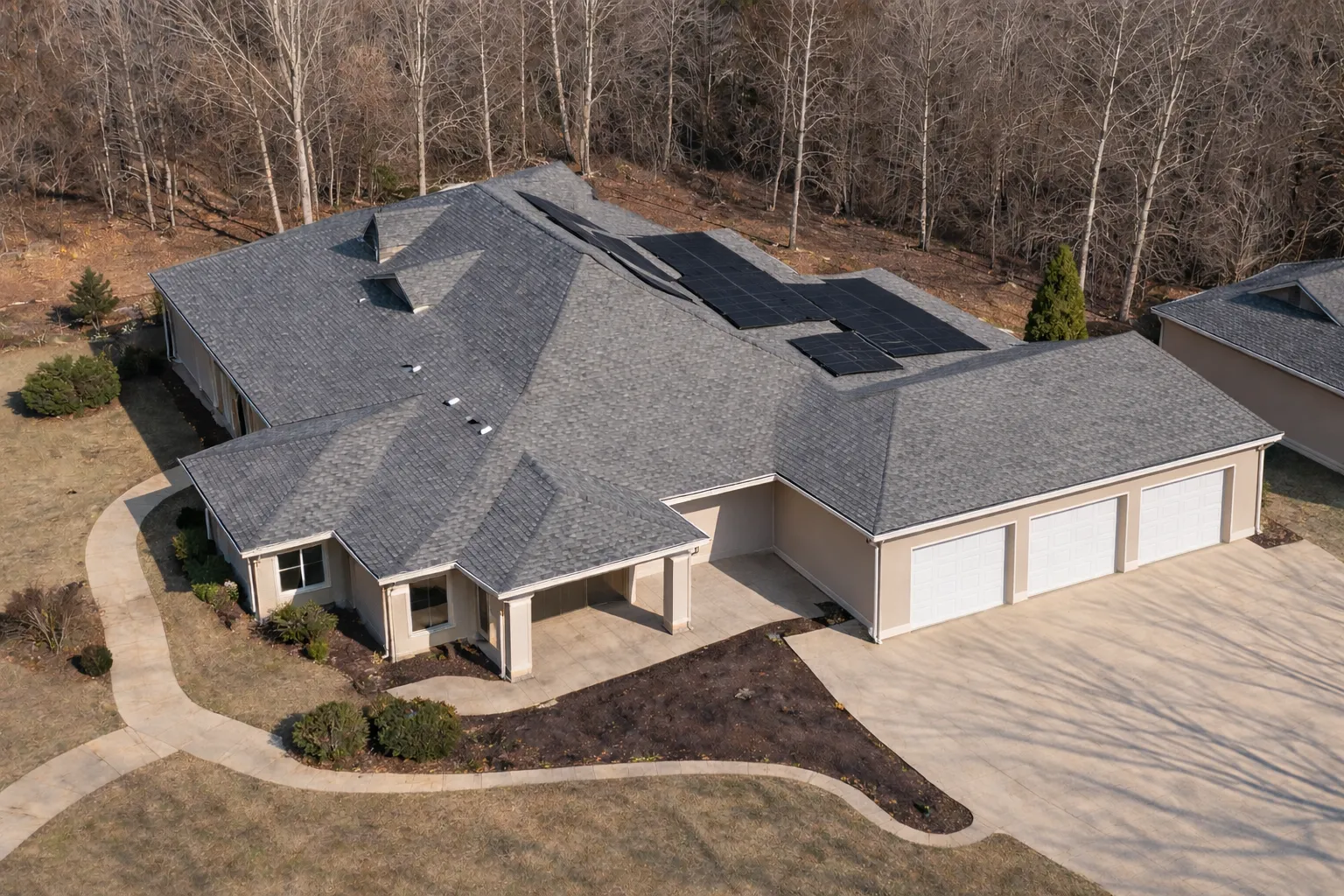 Aerial view of Traditional Ranch style home with stucco exterior, hip roof, and attached three-car side-entry garage