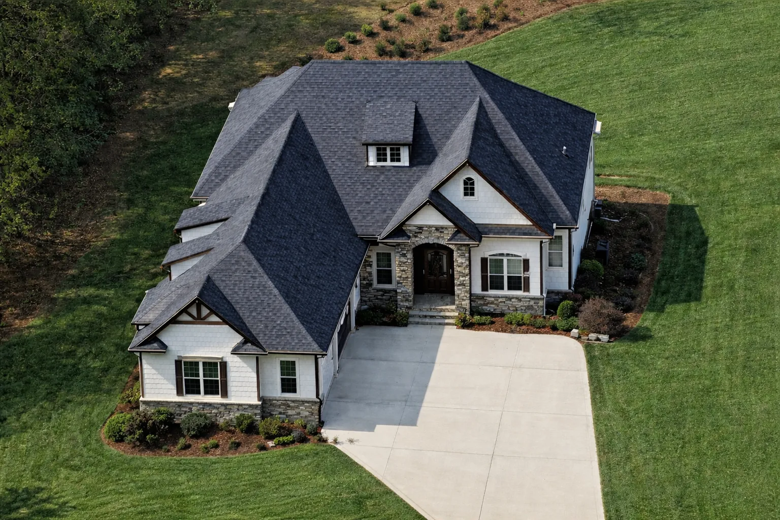 Transitional Ranch House Plans 29 Front exterior of French Country style home with stone and stucco facade, steep hip roof, arched entry, and side-entry garage