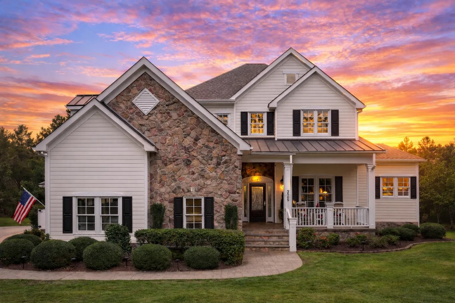 Front elevation of a Traditional Colonial style home featuring brick exterior, lap siding, shuttered windows, and a centered covered front porch