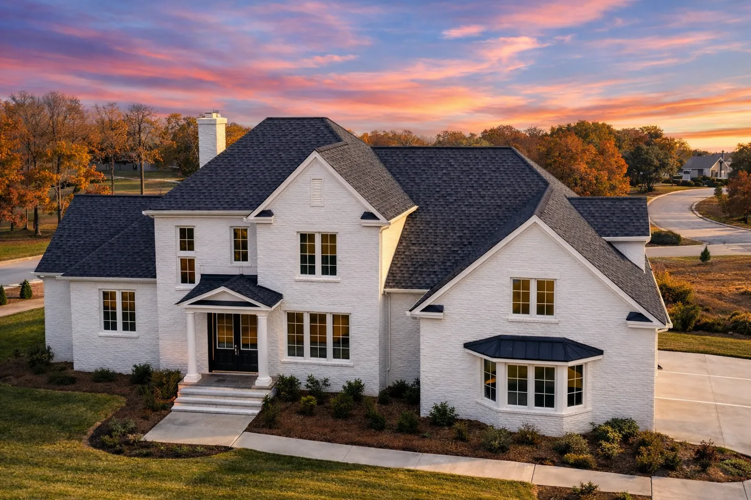 Front elevation of a Modern Farmhouse style home featuring board and batten siding, horizontal lap siding, stone accents, and a symmetrical two-story design