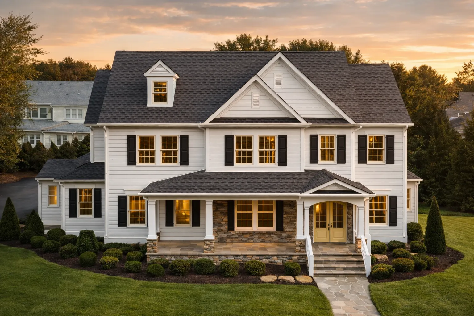 Front elevation of a Traditional Colonial style home featuring white lap siding, stone accents, black shutters, and a covered front porch