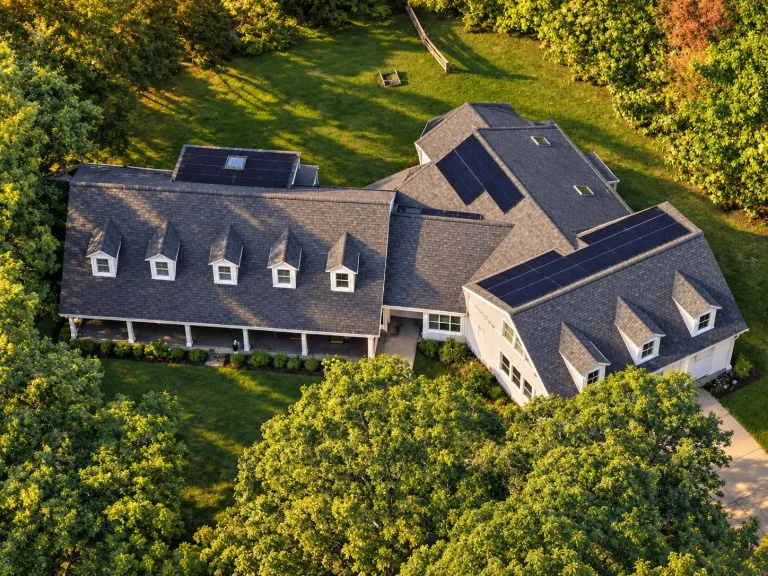 Mid-Size House Plans 22 Front exterior view of a Modern Farmhouse home with navy-blue siding, red doors, dormers, and covered porch showcasing Colonial design influence