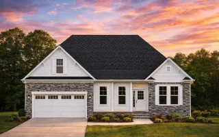Front elevation of a Traditional Ranch and Modern Farmhouse style home featuring board and batten siding, stone wainscoting, dark shutters, and a gable roof design