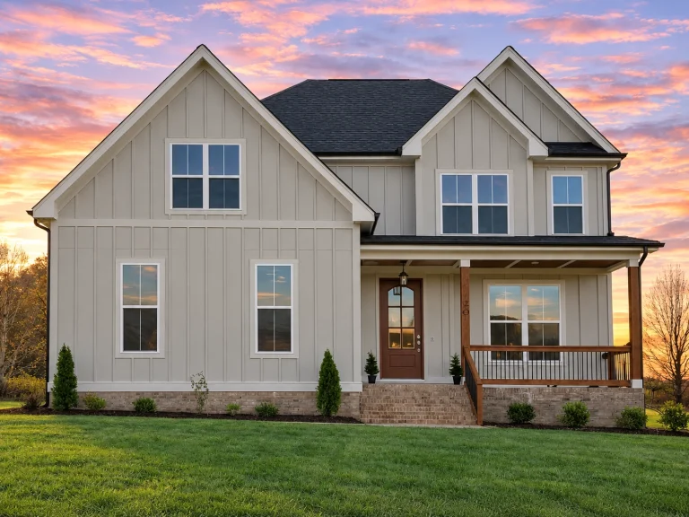 Front elevation of a modern farmhouse style home with white board and batten exterior, stone foundation accents, steep gable roof, and symmetrical windows
