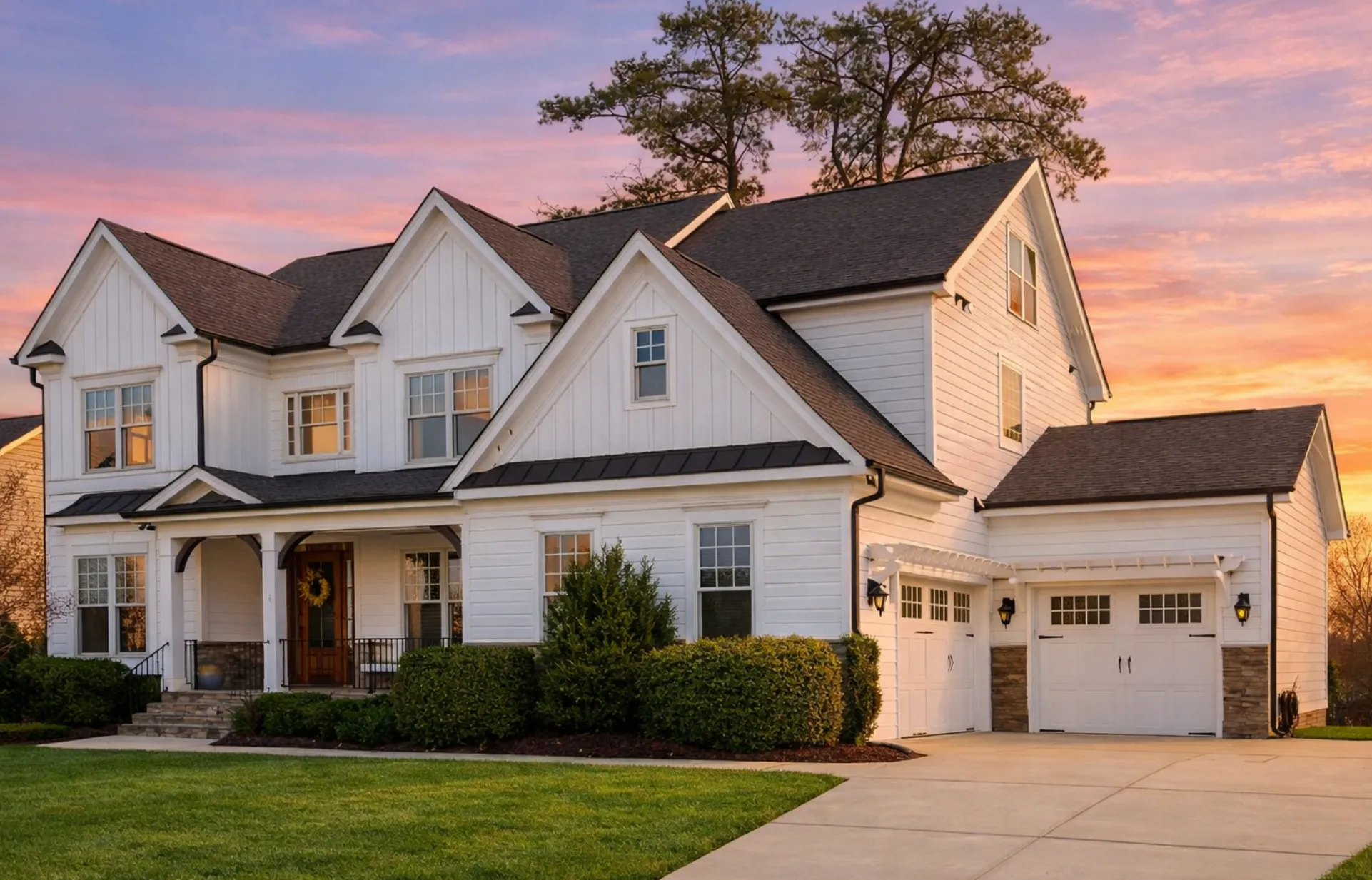 Front elevation of a New American modern farmhouse style home with board and batten siding, stone accents, black shutters, and a covered front porch