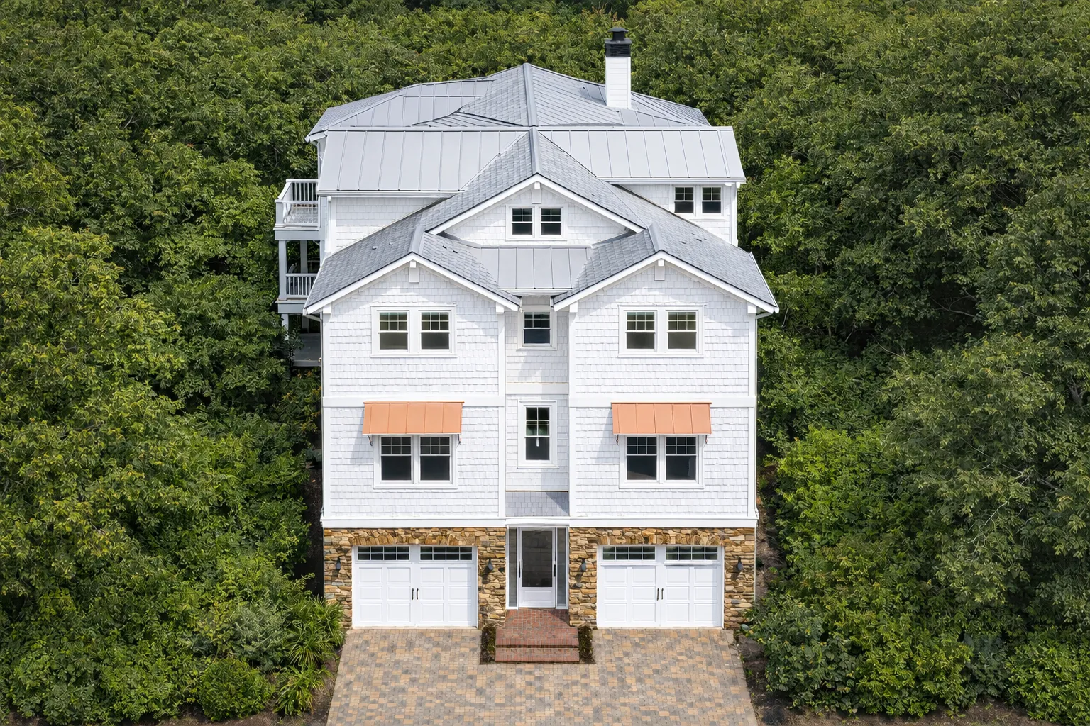 Front elevation of a Coastal Traditional Low Country style home featuring double stacked porches, horizontal siding, and a stone foundation