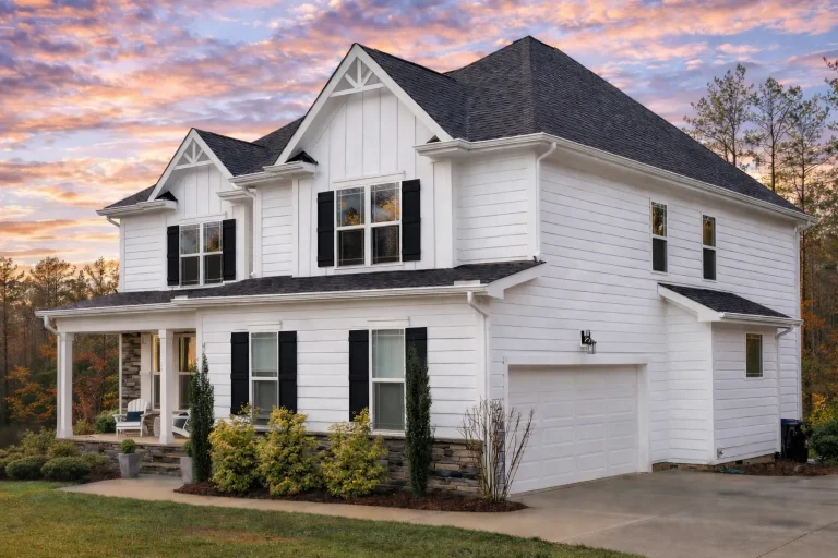Front elevation of a New American modern farmhouse home with board and batten siding, stone accents, black shutters, and symmetrical two-story design