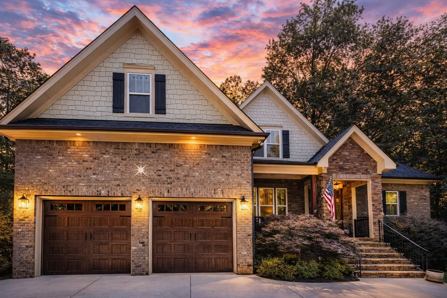 Front view of a Traditional Transitional style home featuring horizontal lap siding, stone accents, and board-and-batten gables with a welcoming covered porch entry