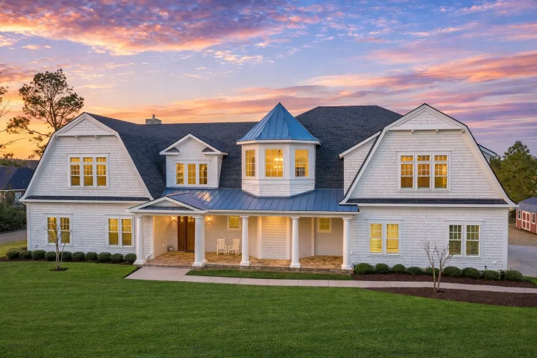 Front elevation of a Cape Cod style home with Colonial Revival symmetry, lap siding, gabled roof, and centered entry