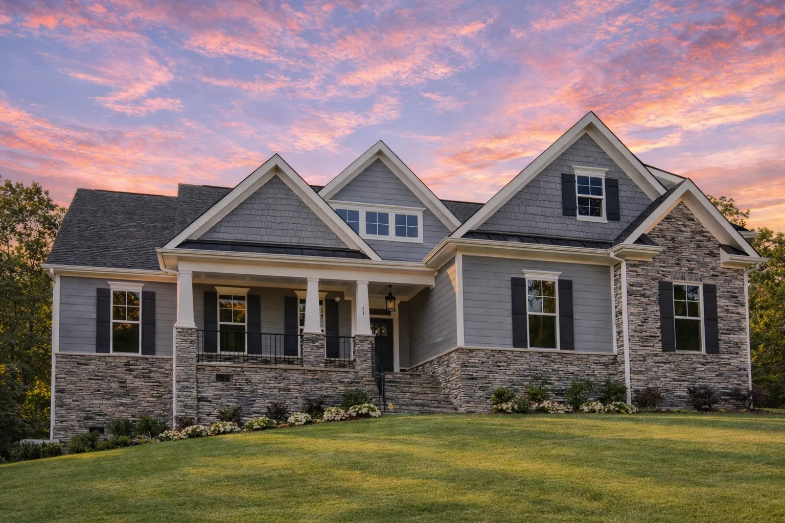 Front elevation of a New American modern traditional house featuring stone accents, horizontal siding, gabled rooflines, and a covered front porch