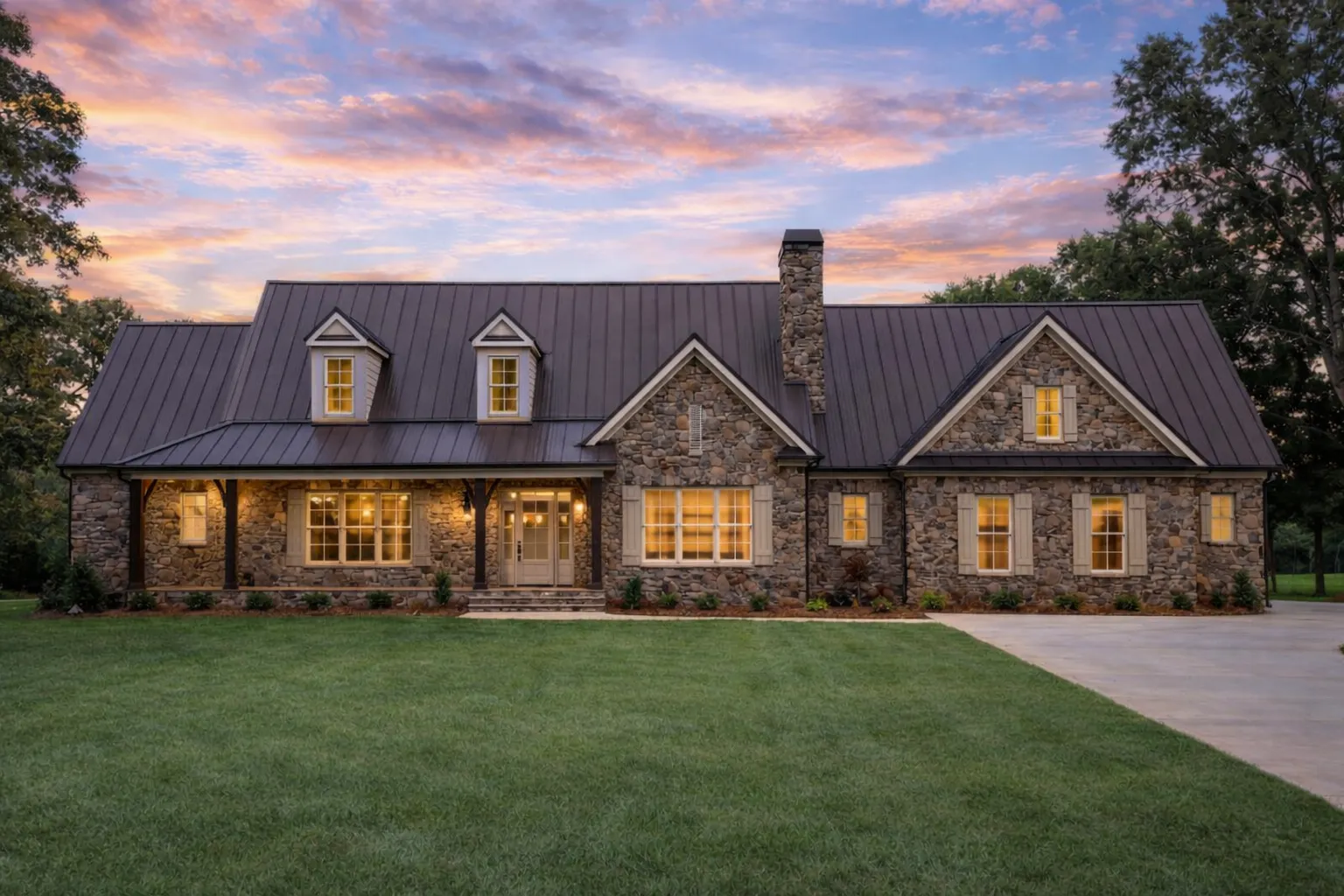 Front elevation of New American Traditional style house with stone facade, white lap siding, gabled roof, and covered front porch