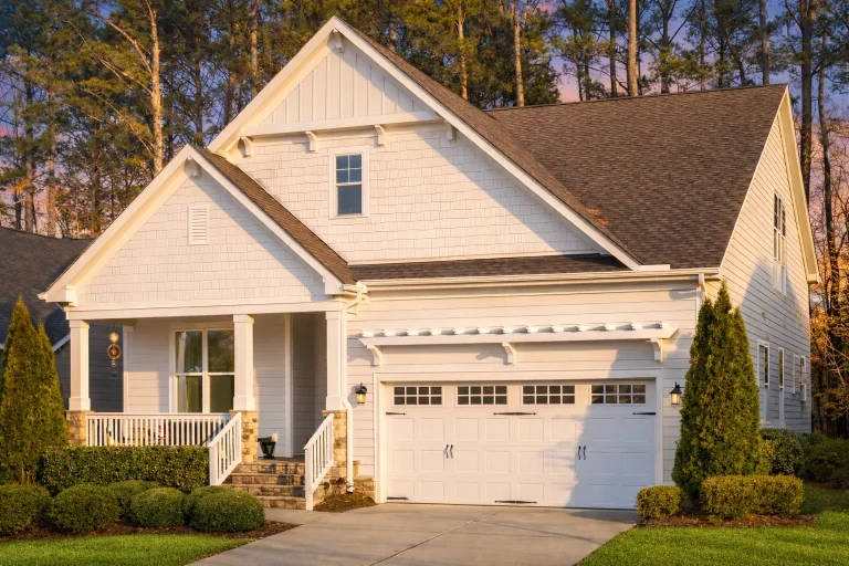 Front elevation of a Craftsman farmhouse style home featuring board and batten siding, stone accents, gabled rooflines, and a covered porch