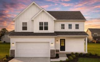 Front elevation of a New American farmhouse style home with blue horizontal siding, board and batten accents, stone base, and attached two car garage