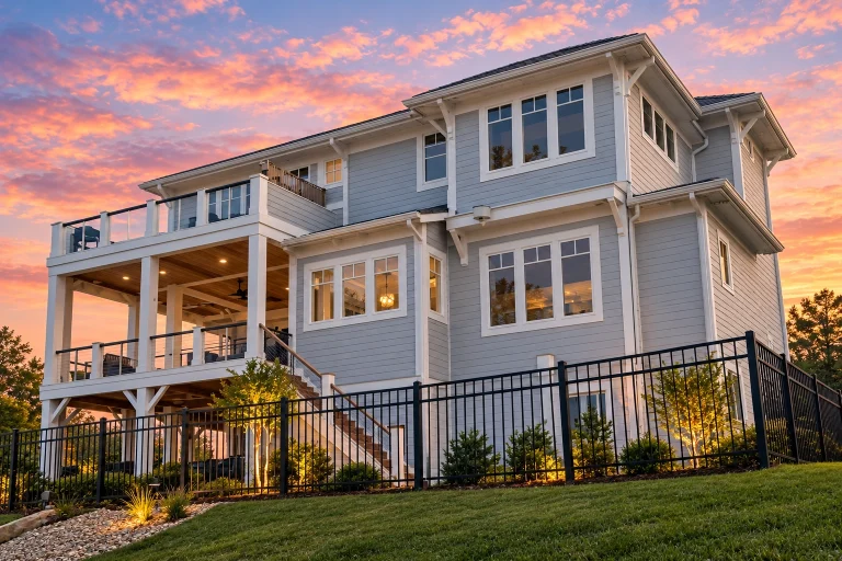 Top Designer-Approved House Plans 7 Front elevation of a Coastal Traditional Southern home with lap siding, stone accents, double porches, and elevated garage design