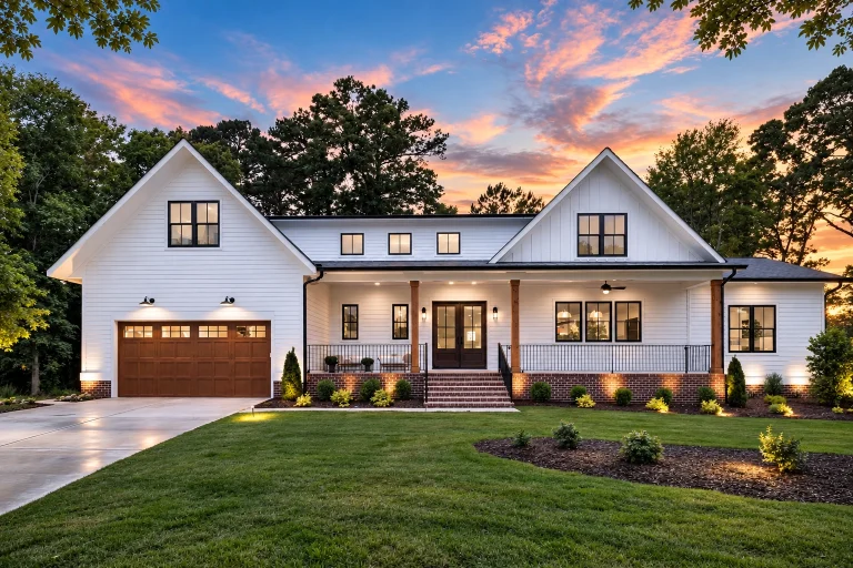 Front exterior view of a modern farmhouse style home with Craftsman influences, board and batten gables, horizontal siding, covered porch, and attached garage