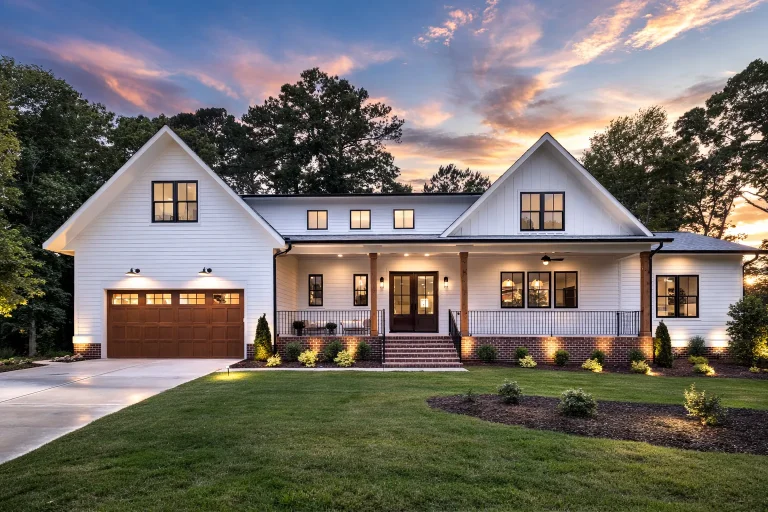 Front exterior view of a modern farmhouse style home with Craftsman influences, board and batten gables, horizontal siding, covered porch, and attached garage