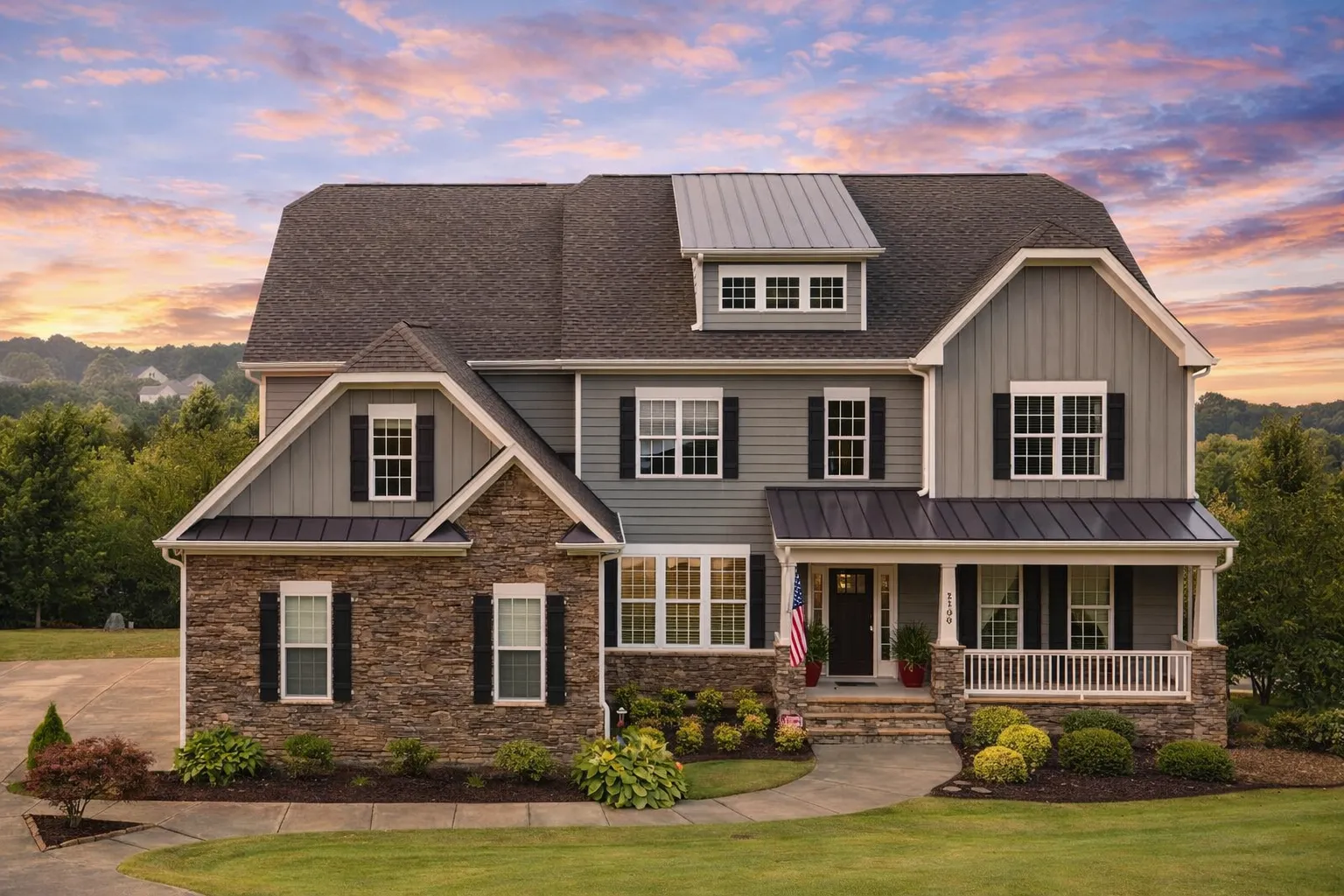 Front elevation of a New American Colonial style home featuring lap siding, stone porch accents, symmetrical windows, and a steep shingle roof