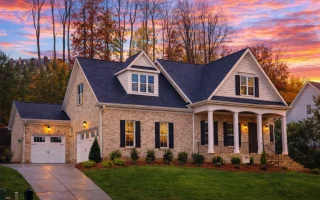 Front elevation of a New American modern traditional house featuring board and batten siding, stone accents, gabled rooflines, and an inviting arched entry