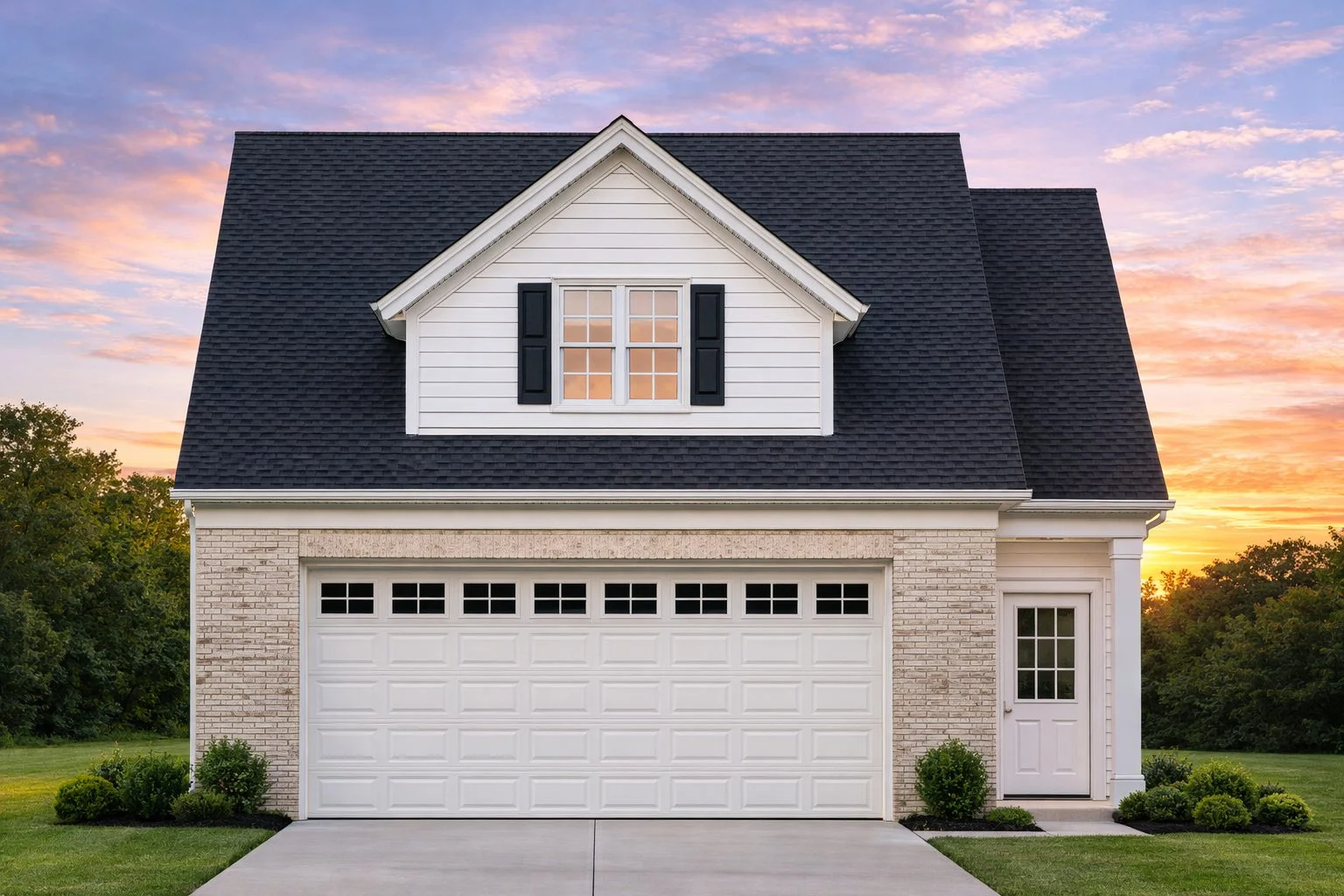 Front elevation of a Traditional Suburban home featuring horizontal siding, stone accents, a gable dormer, and a two-car garage