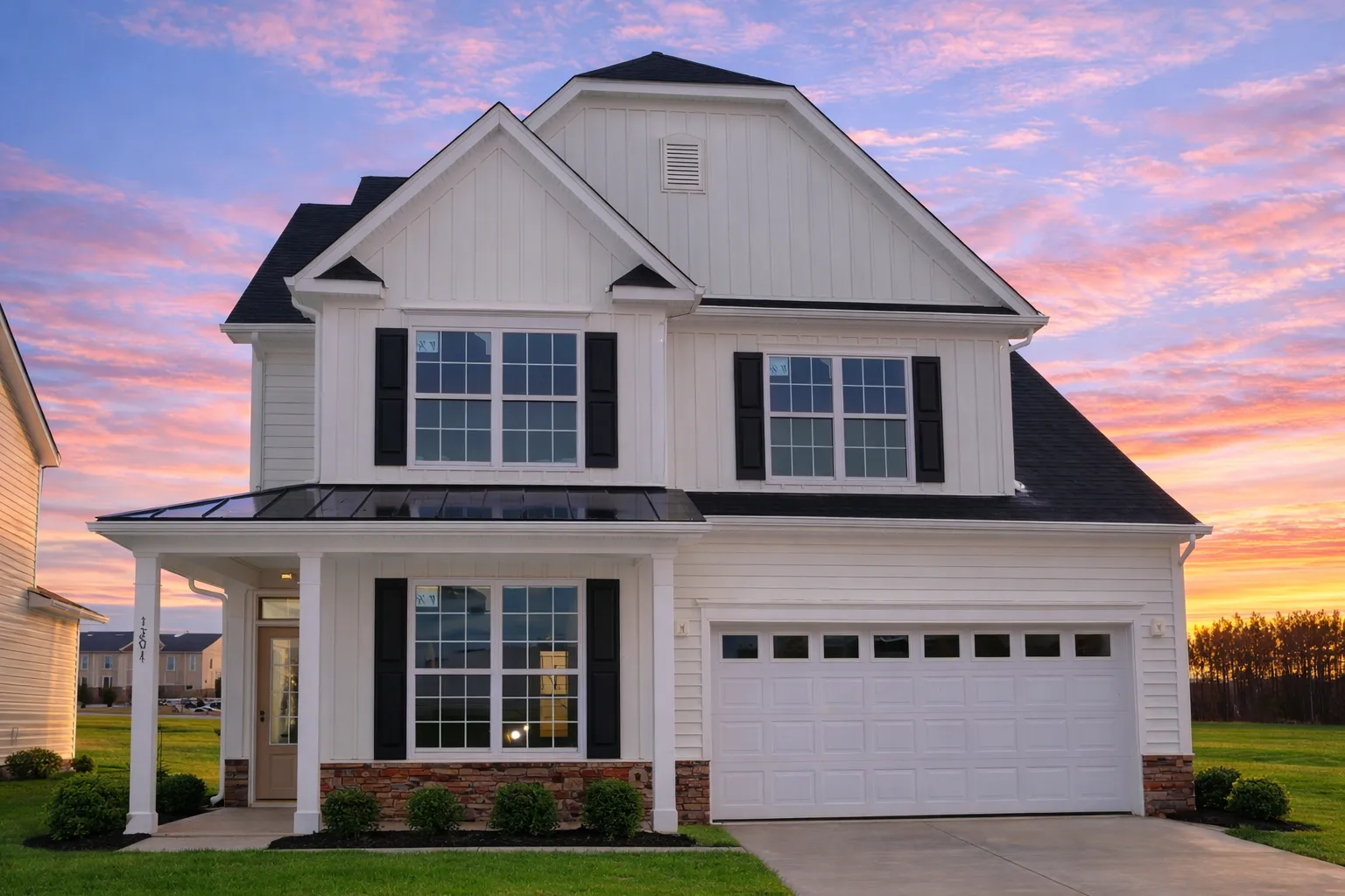 Front elevation of a modern farmhouse with white horizontal siding, board and batten gable, stone base, and attached two-car garage