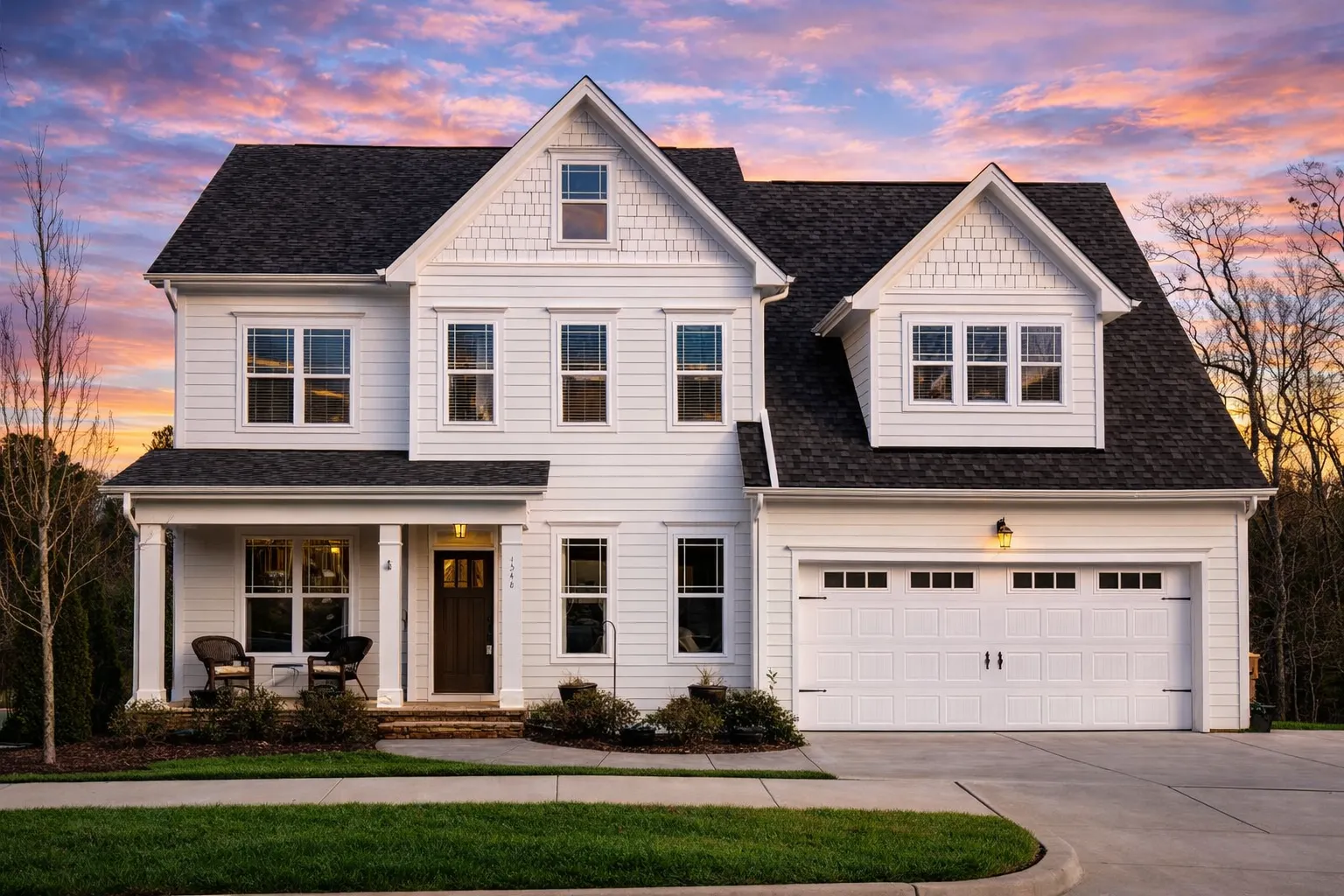 Front exterior of a New American Modern Traditional style home with horizontal lap siding, symmetrical façade, front porch, and attached two-car garage