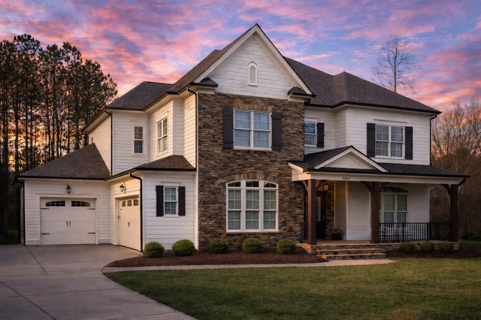 Front elevation of a New American Modern Traditional house featuring stone veneer, horizontal siding, black shutters, and a symmetrical Colonial-inspired façade
