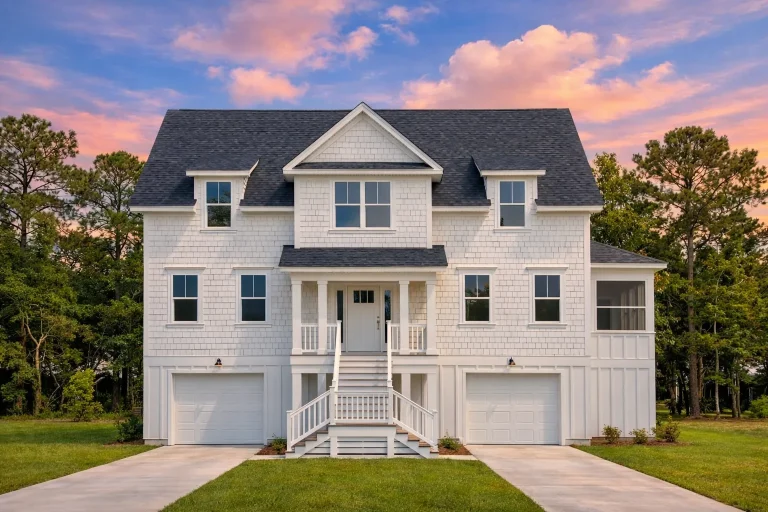 Front elevation of a Modern Farmhouse with board and batten siding, stone foundation, black windows, and dual garage design