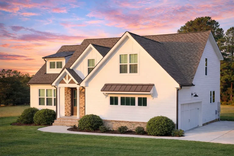 Front elevation of a New American Modern Traditional house featuring painted brick, board and batten siding, steep gables, and a covered entry porch