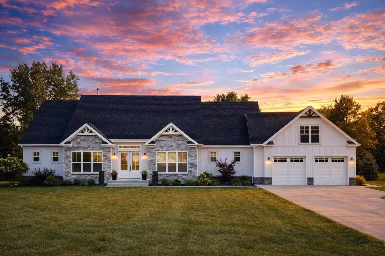 Front elevation of a Traditional Ranch style home with horizontal siding, stone accents, gabled rooflines, and attached two-car garage