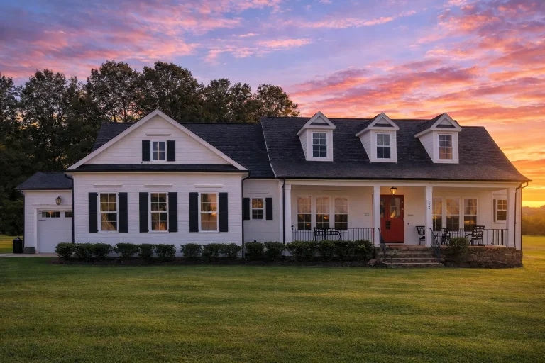 Front exterior of a Cape Cod style home with brick exterior, symmetrical windows, dormer roof, and traditional covered entry