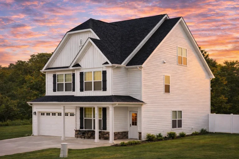 Front exterior view of a New American style two-story home with horizontal siding, board and batten gables, covered front porch, and attached garage