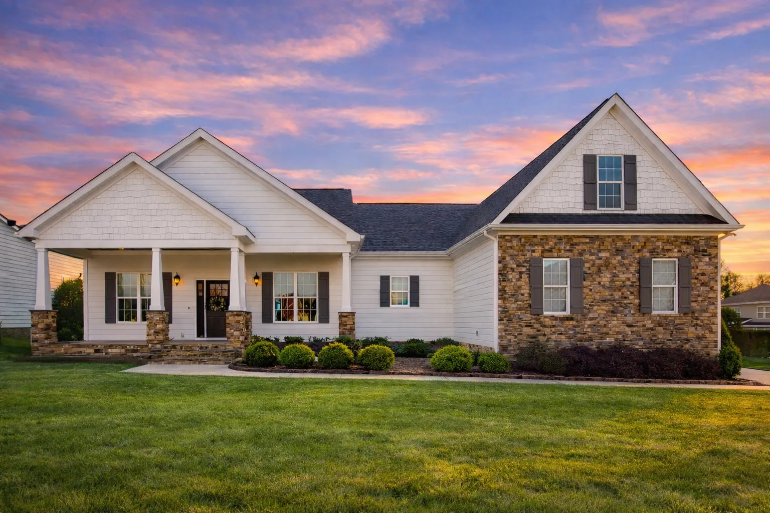 Front elevation of a Traditional Ranch style home featuring brick accents, horizontal siding, board-and-batten details, and a covered front porch