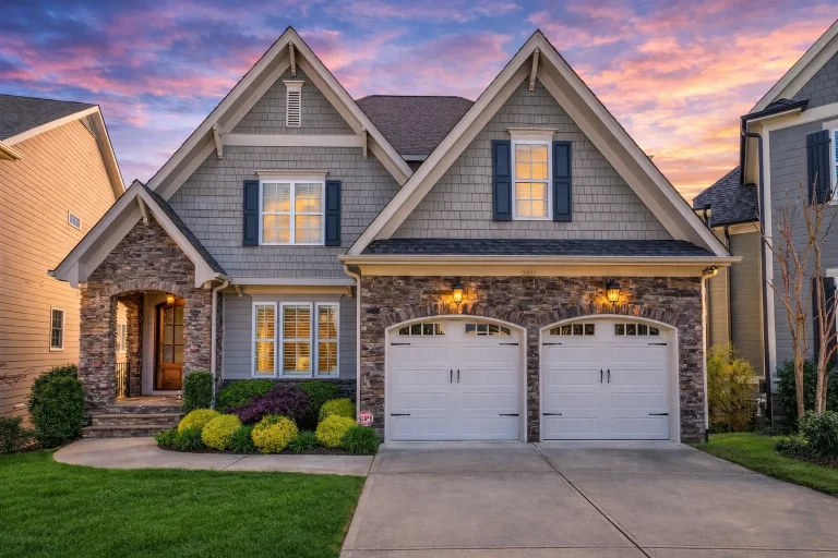 Front elevation of a Traditional New American style home with brick exterior, stone accents, Craftsman gables, and double front-entry garage