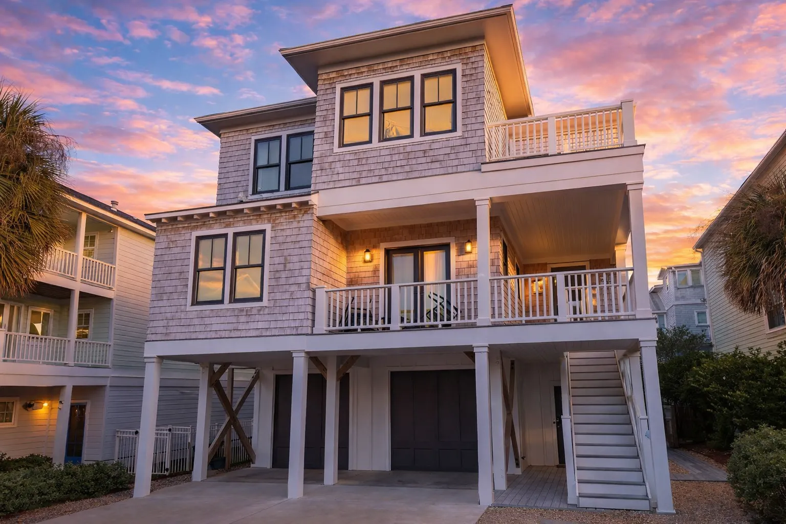 House Plans with Open Floor Plan 5 Front elevation of Coastal Shingle Style beach house with shingle siding, elevated foundation, covered porches, and exterior stairs