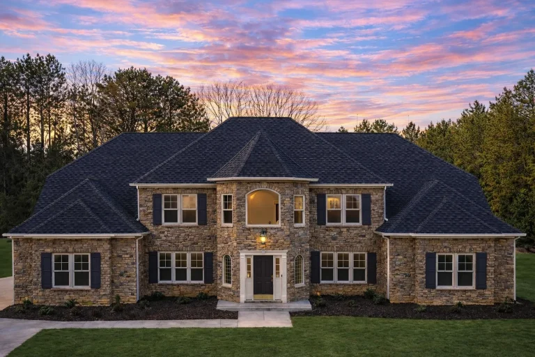 Front elevation of a Neo-Colonial luxury home featuring symmetrical design, brick exterior, stone entry surround, and classic shutters