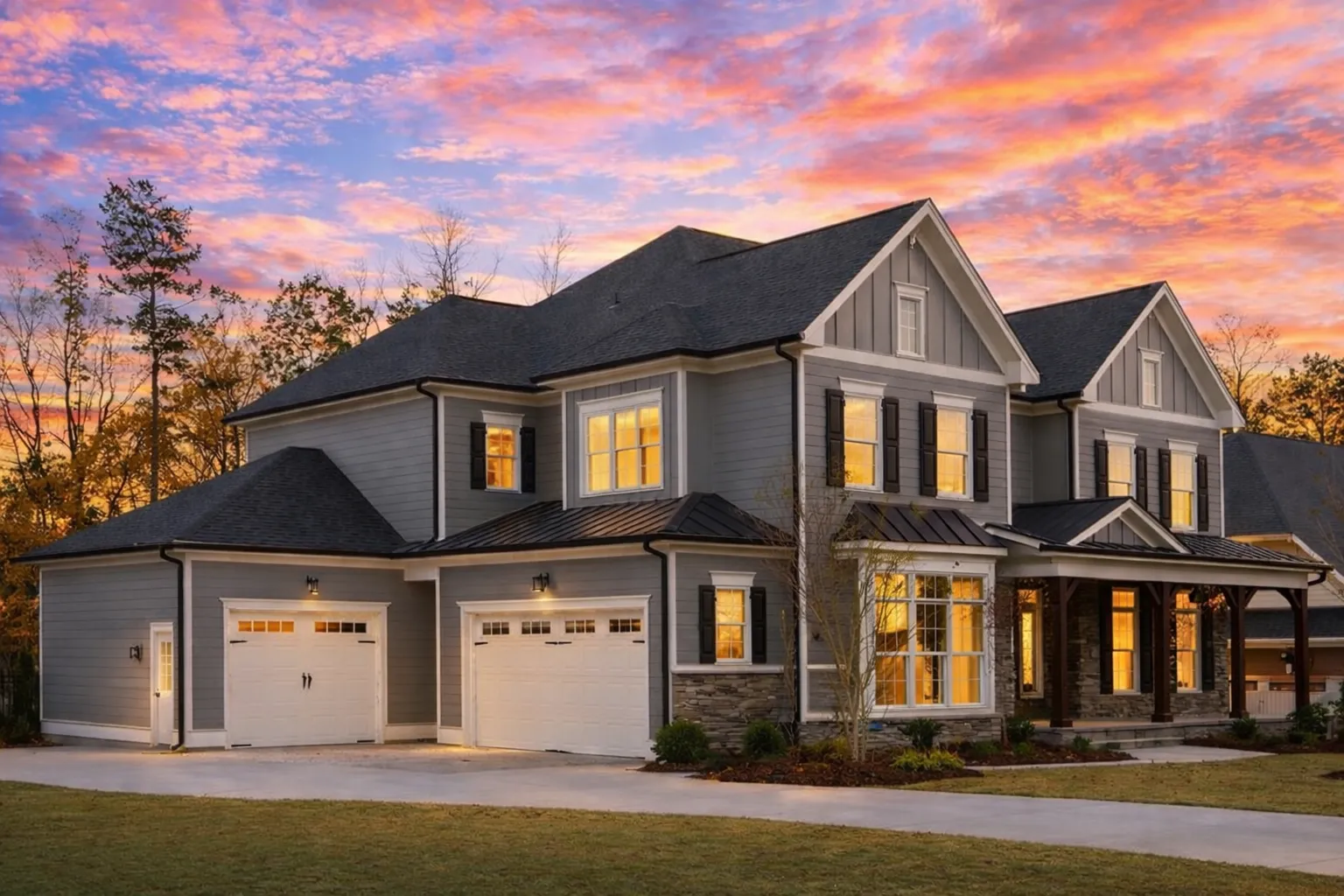 Front elevation of a New American modern traditional home with board-and-batten siding, stone accents, symmetrical windows, and a covered entry porch