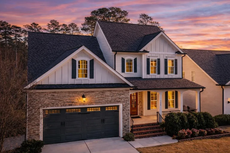 Front elevation of a Traditional Colonial style home with lap siding, stone-accented garage, symmetrical windows, and covered front porch