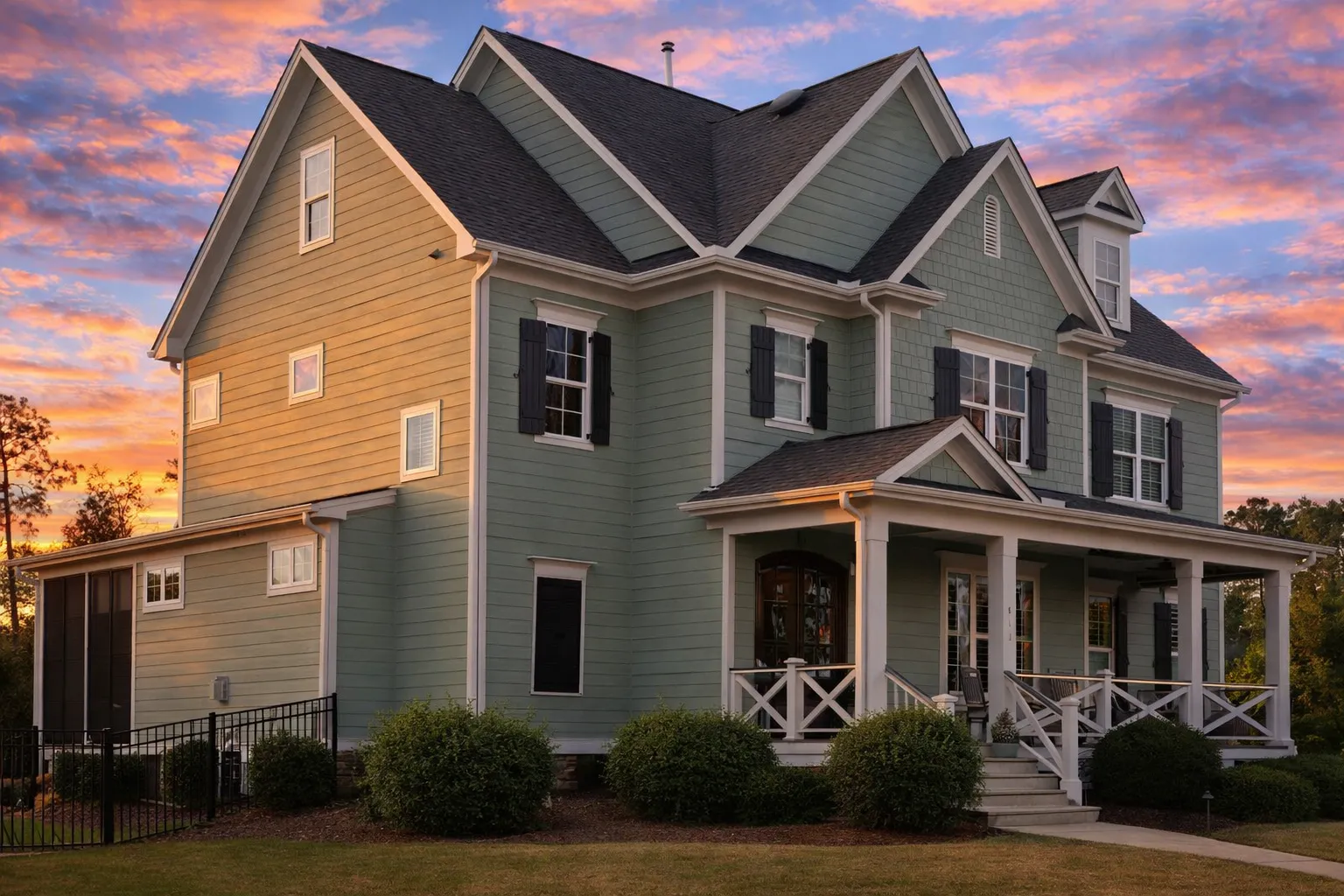 Front elevation of a New American traditional home with Colonial influence, featuring horizontal siding, stone accents, symmetrical windows, and a covered front porch