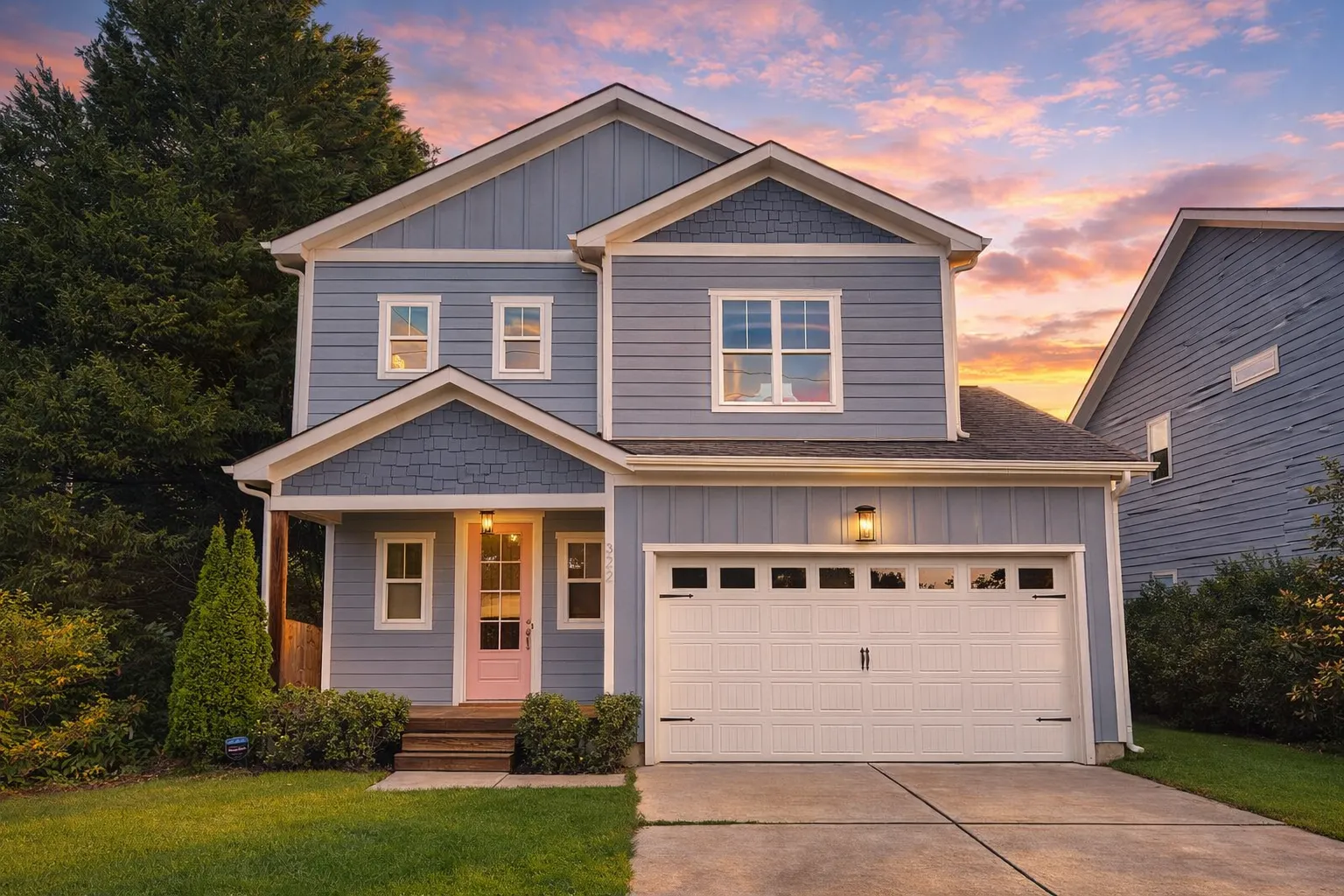 Front elevation of a New American style two-story home with horizontal siding, shingle gable accent, and attached two-car garage