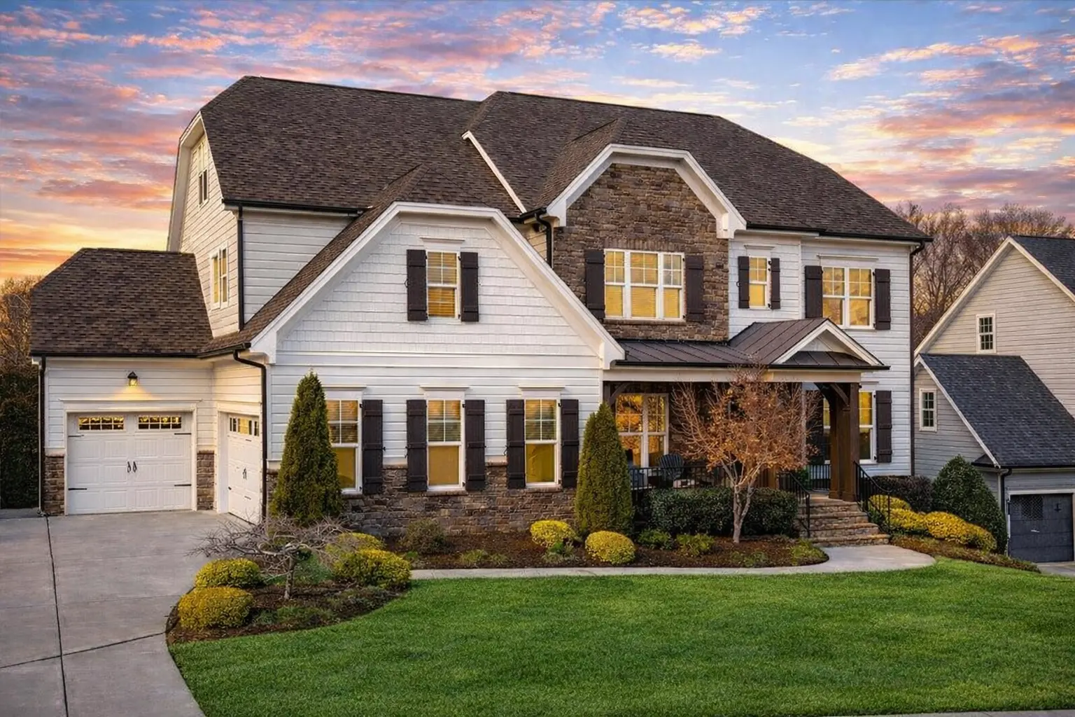 Front exterior of a New American Traditional Colonial style home featuring lap siding, stone accents, symmetrical windows, and an arched entry