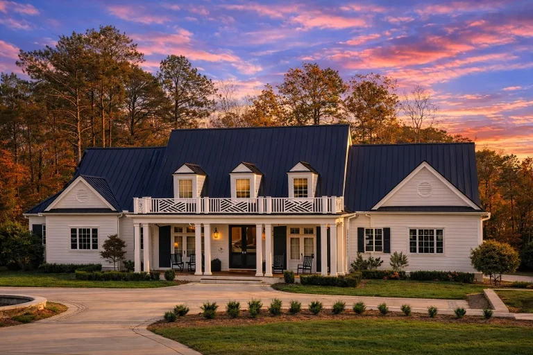 Front elevation of a Southern Farmhouse style home with painted brick exterior, standing seam metal roof, symmetrical dormers, and wide covered front porch