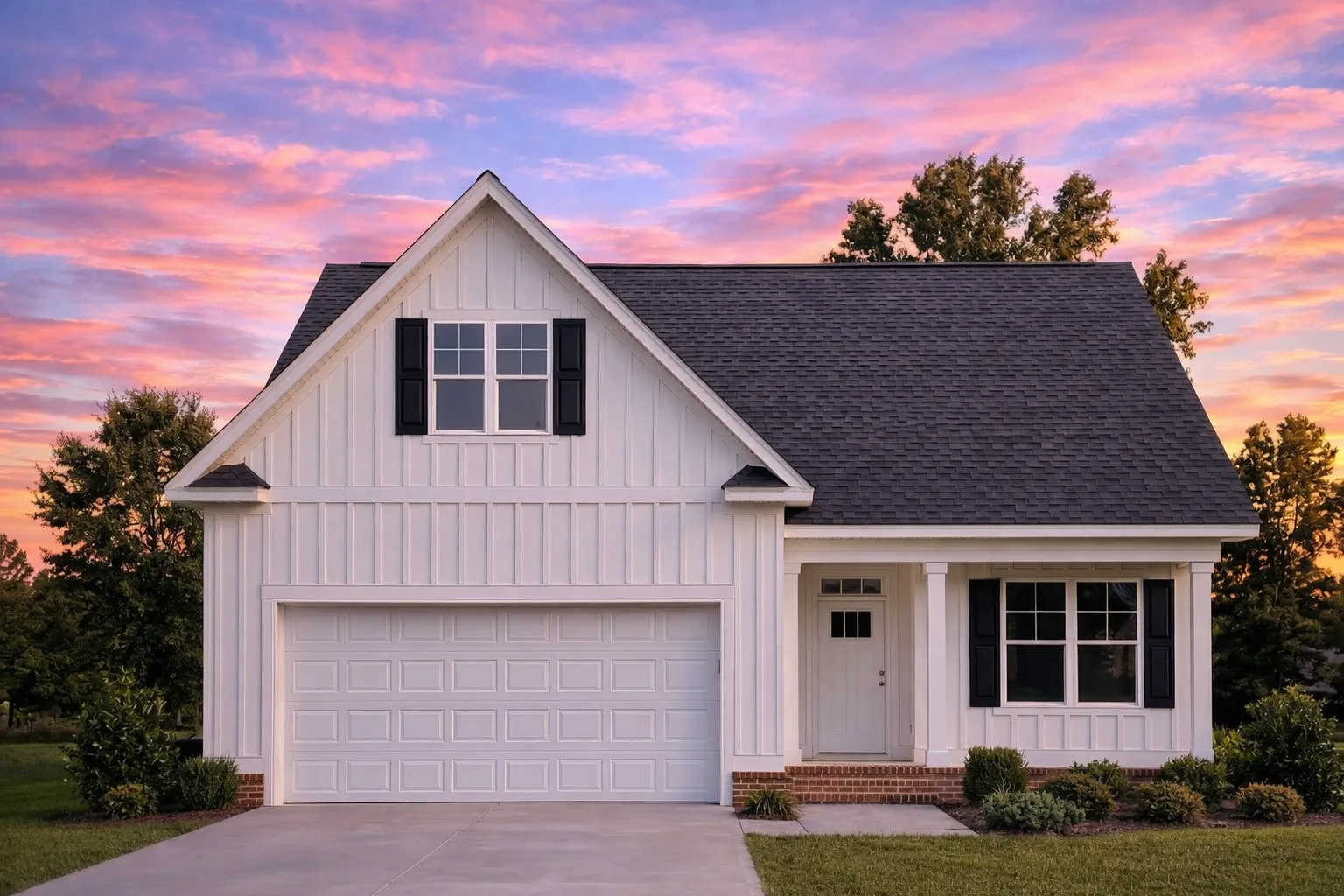 Front elevation of a Modern Farmhouse home featuring white board and batten siding, black windows, and a simple gable roof design