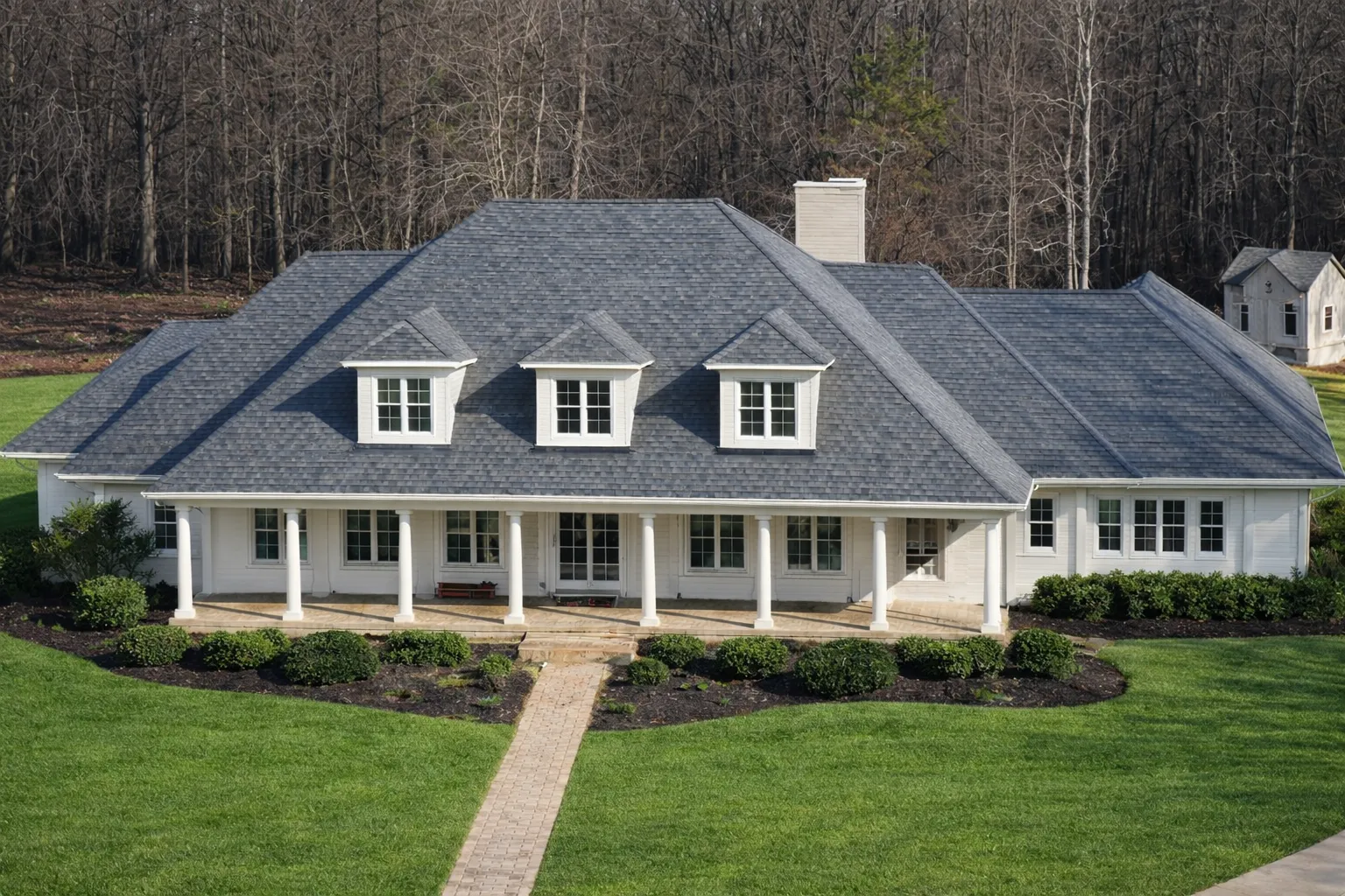 Front elevation of a Classical Southern Colonial style home featuring white horizontal siding, a full-width covered porch with columns, dormer windows, and a balanced symmetrical facade
